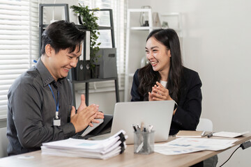 Diverse business partners discussing ideas and sharing laughter in the office.