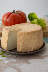 Cheese collection, piece of round fresh smoked Spanish goat cheese close up