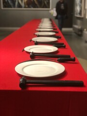 White plates with hammer and sickle on red tablecloth and long wooden table