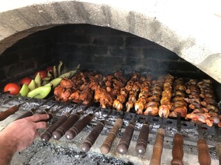 Fried shashlik tomatoes peppers in a stone grill and barbecue