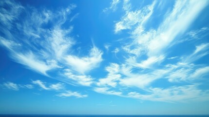A clear summer sky, endless blue expanse with a few wispy clouds in the distance.