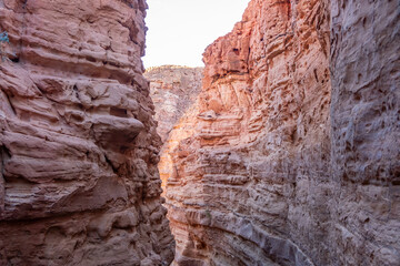 Exploring the stunning rock formations and narrow pathways of Tsvetnoy Canyon in Egypt during golden hour