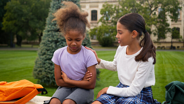African Latina pupils primary school education little girls teen students schoolgirls studying children kids sad upset offended worried conflict sorry friend calm help support friendship city outdoors