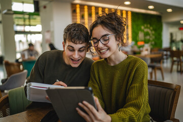 couple learn together and prepare exam on digital tablet at cafe