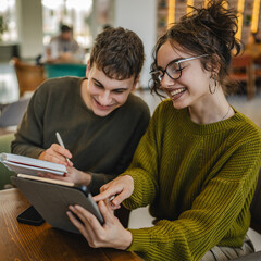 couple learn together and prepare exam on digital tablet at cafe
