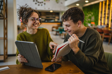 couple learn together and prepare exam on digital tablet at cafe