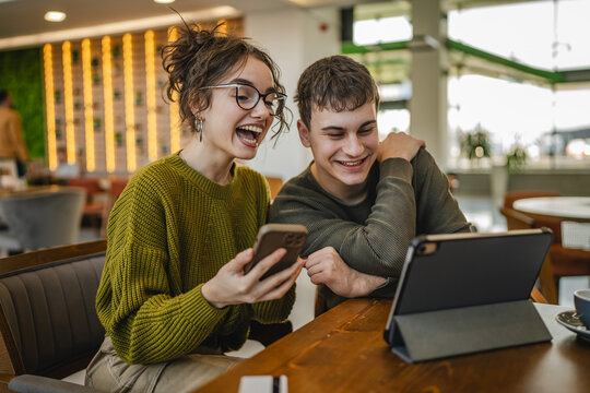 couple explore internet on mobile phone and digital tablet at cafe