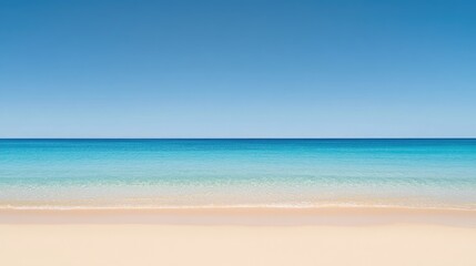 Fototapeta premium A wide expanse of untouched beach sand leading to a calm blue sea under clear skies.