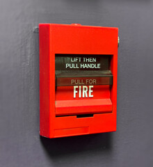 Red Fire Alarm Pull Station on Dark Wall – Emergency Safety Equipment