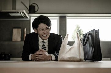 残業で疲労・疲弊して帰宅したビジネスマン（過労・悩む・離婚・落ち込む・絶望・激務）
