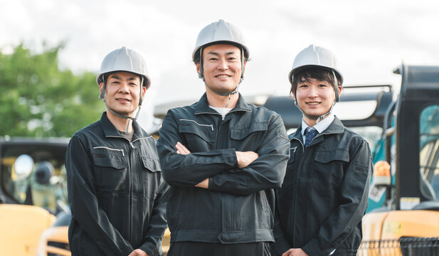 重機の前にいる作業着姿の建設業・建築業の作業員男性ビジネスマン
