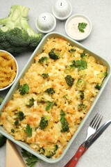 Tasty pasta casserole with cheese and broccoli served on grey table, flat lay