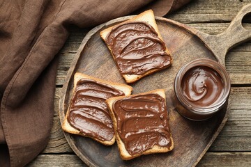 Tasty sandwiches with chocolate butter on wooden table, top view
