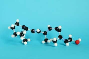 Molecule of retinol (vitamin A) on light blue background. Chemical model