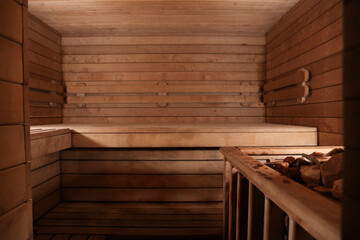 Wooden sauna with bench and hot stones