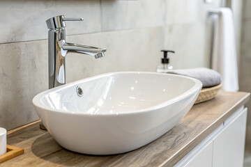 Fototapeta premium Modern bathroom sink with sleek faucet and wooden countertop