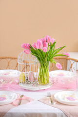 Beautiful table setting with tulip flowers for International Women's Day near color wall