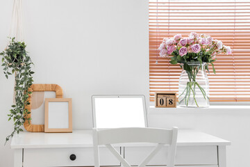 Calendar with date of International Women's Day and roses on windowsill in office