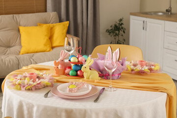 Festive table serving with painted eggs and bunnies for Easter celebration in kitchen