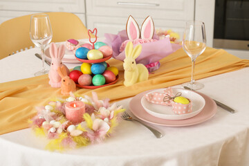 Festive table serving with painted eggs and bunnies for Easter celebration