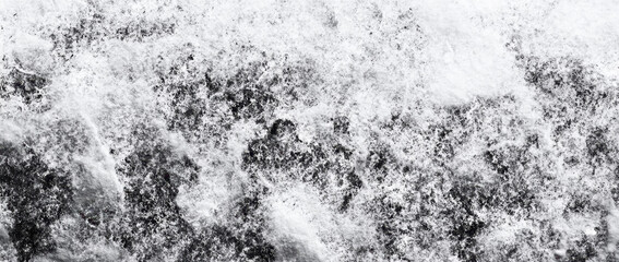 Abstract black and white texture with grainy appearance, resembling snowy landscape or rough surface. This evokes sense of calm and simplicity