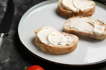 Plate of tasty bruschetta with processed cheese on black background, closeup