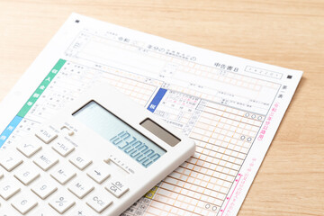 机に置かれた確定申告書類と電卓