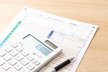 机に置かれた確定申告書類と電卓