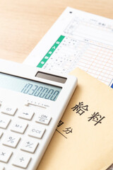 机に置かれた確定申告書類と電卓と給料袋