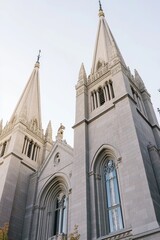 Fototapeta premium Majestic architecture of a historic church with tall spires against a clear sky in the late afternoon light