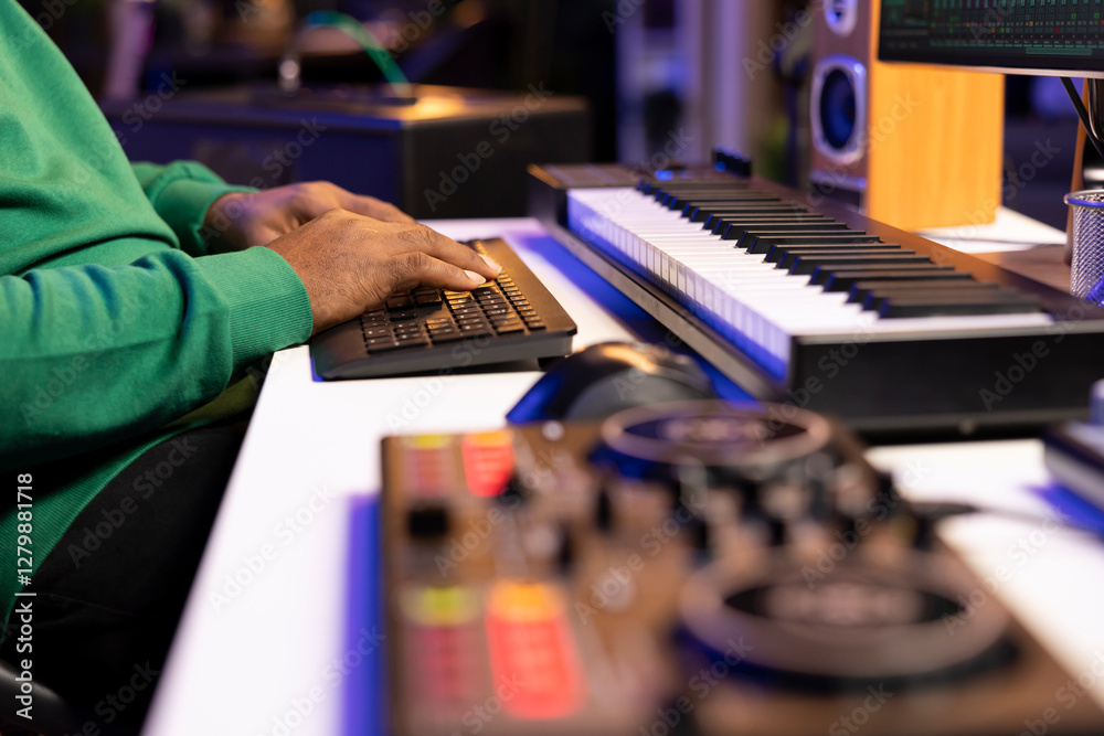Leinwandbilder Sound engineer working with mixing console and daw software to edit audio recordings, adjusting volume levels with pre amp knobs in his home studio. Producer uses stereo gear. Close up.