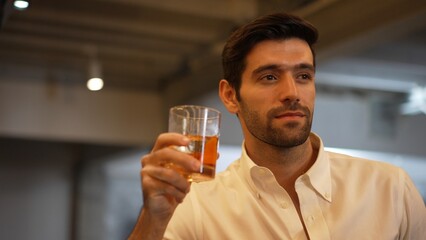 Profile closeup of smiling smart man in white shirt drinking cocktail in Old fashioned of special party beverage vibrant at nightclub on Friday meeting night time at luxurious counter bar. Vinosity.