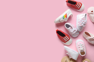 Different cute baby booties on pink background