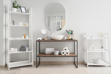 Interior of bathroom with sink, shelf units and cosmetic products