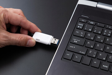 パソコンにUSBメモリを差し込む手元