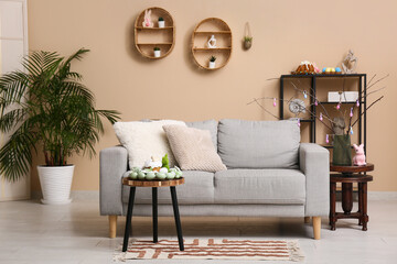 Interior of living room with sofa, Easter cake and eggs on table