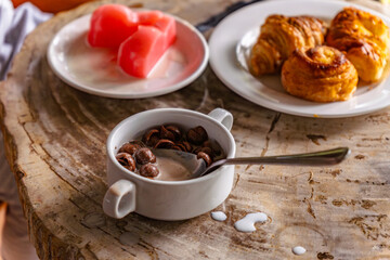 A bowl of chocolate flavored cereal with fresh milk, representing a children's breakfast concept