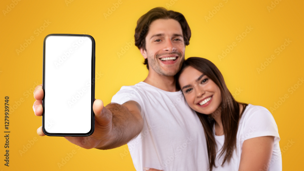 Poster using cool application. portrait of cute millennial couple holding smartphone with white screen in h