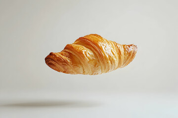Golden and Flaky Croissant Levitating on a Light Background