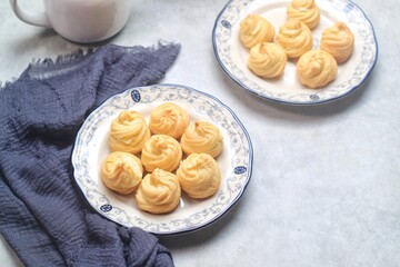 Kue Sus Isi Vla or soes cake (Choux Pastry Cream Puff) is Crispy and airy choux pastry shell are filled with smooth and soft custard cream. served in a plate.

