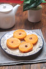 Kue Lumpur or Mud Cake, Indonesian traditional cake made from potato, flour, eggs and coconut milk topped with raisins served on white plate.
