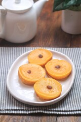 Kue Lumpur or Mud Cake, Indonesian traditional cake made from potato, flour, eggs and coconut milk topped with raisins served on white plate.
