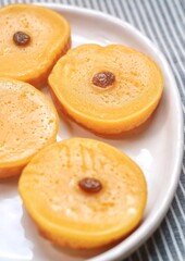 Kue Lumpur or Mud Cake, Indonesian traditional cake made from potato, flour, eggs and coconut milk topped with raisins served on white plate.
