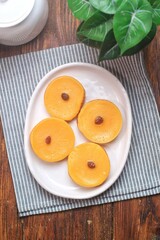 Kue Lumpur or Mud Cake, Indonesian traditional cake made from potato, flour, eggs and coconut milk topped with raisins served on white plate.
