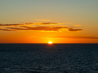 Obraz premium Sunset over the Pacific Ocean, with the sun slowly continuing to set.