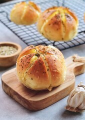 Korean Garlic and Cheese Bread (Yugjjog Maneulppang) is Popular Street Food in Korea. Made from Bread Bun, Cream Cheese, Garlic, Oregano and Honey. Isolated on wodden bowl. Warm ton
