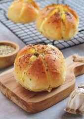 Korean Garlic and Cheese Bread (Yugjjog Maneulppang) is Popular Street Food in Korea. Made from Bread Bun, Cream Cheese, Garlic, Oregano and Honey. Isolated on wodden bowl. Warm ton
