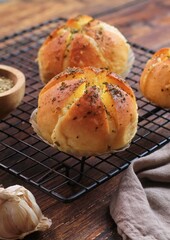 Korean Garlic and Cheese Bread (Yugjjog Maneulppang) is Popular Street Food in Korea. Made from Bread Bun, Cream Cheese, Garlic, Oregano and Honey. Isolated on wodden bowl. Warm ton
