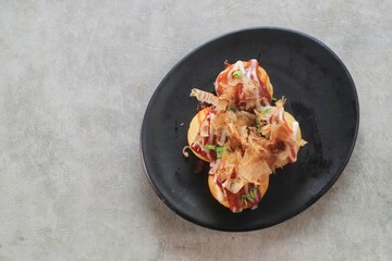 Takoyaki is japanese street food with sauce, mayonaise and katsuobushi as topping and octopus filing, popular street food.