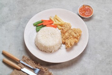 Crispy Chicken Steak with french fries and vegetables and rice
